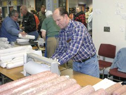 Tonasket dentist and Kiwanian Rob Nau sells sausage at the dinner. The Kiwanis club sold bulk meat in addition to plates of cooked food. Photo by Amy Veneziano