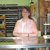 Photo by Amy Veneziano Stephanie Bradley stands behind a new trophy case installed recently at II Sisters Video Store. The Bradley’s bought the store and added the trophy and sign-making business in April.