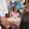 Photo by Amy Veneziano With her crown complete, one little girl picks out the perfect paper for a hand fan from helper Mishara, 13 years old.