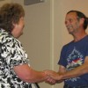 Tonasket Mayor Patrick Walter shakes hands with Cathy Moore after giving her a certificate of appreciation for her work as the city utilities clerk for the past 30 years. Photo by Emily Hanson