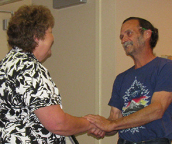 Tonasket Mayor Patrick Walter shakes hands with Cathy Moore after giving her a certificate of appreciation for her work as the city utilities clerk for the past 30 years. Photo by Emily Hanson