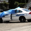 Officer Patterson's Patrol Car in the Oroville equipment yard behind the Depot Museum. Covered with a blue tarp, much of the wreckage is hidden from view, but emergency personal at the scene described the damage caused by the collision with a cow on Hwy.