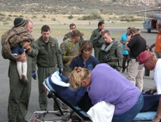 Oroville Ambulance Crew members Debora Donohue, Lisa Bordwell and Brad Calico prepare to load a gurney with a female believed to be suffering from hypothermia. The child and the two male sujects (seen here in camo shirt and bright blue shirt) were also tr