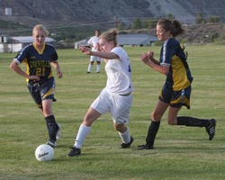 Tonasket’s Michelle Timmerman (middle) pulls back to kick the ball between Oroville’s Naomi Peters (21) and Catie Arrigoni during the Tigers’ home game against the Hornets on Tuesday, Sept. 8. The game ended in a 4-4 tie.Photo by Terry Mills