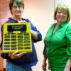 Tonasket City Councilmember Jean Ramsey along with City Clerk Alice Attwood displaying the name plaque honoring the people who donated money so the Holiday Light Committee could buy new snowflake holiday lights which have been on display on poles througho