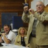 Okanogan County PUD Commissioner Ernie Bolz (standing) answers a question from the audience at a special meeting of the PUD Commissioners held at the Oroville Depot. Bolz and his fellow commissioners, David Womach and Trish Butler, as well as District Man