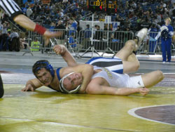 Tonasket senior Keegan McCormick smiles at his coaches during his first round in the 171 weight class of the 1A Division at the 2011 Washington State Mat Classic XXIII Championship on Friday, Feb. 18 as he successfully does the leg ride-turk move against 