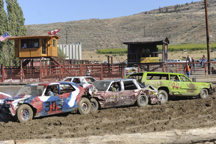 Brandon Weller in the #44 car, the lime green Rough and Tough station wagon, helps to sandwich another car during the Tonasket Demolition Derby presented by the Commancheros Rodeo Club. Weller won three heats and the overall prize as the last car still ru