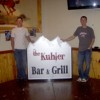 Zach and Josh Kuhlmann pose by the new Kuhler Bar and Grill sign which is now up on it's post in front of their business at the home of the former Tonasket Saloon. Photo by Charlene Helm