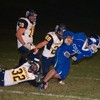 The Hornets' Angel Camacho hangs onto the ankle of Warden running back Adam Hansen during Oroville's 34-2 loss to the Cougars.