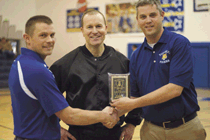 Photo by Brent Baker — Tonasket girls basketball coach Mike Larson (left) and athletic director Kevin Terris (right) accept the Okanogan Valley Officials Association Good Sportsmanship Award prior to Thursday's game with Omak. Presenting the award on be