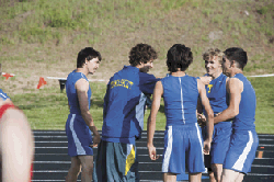 Brent Baker / staff photo - Damon Halvorsen (second from left), who later would qualify for state in the 3200, celebrates with the 4x100 relay team of Zach Villalva, Smith Condon, John Stedtfeld and Jake Hickman after their own state qualifying run.