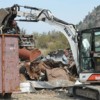 Chris Celli loads scrap metal into a container that will be trucked to the coast and loaded on ships for reuse elsewhere. Celli buys several types of scrap metal at his CNC BuyBack Center, just south of Oroville on SR97. Photo by Gary DeVon