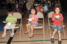 Christopher Castillo, age two, Keyli Castillo, age three and Kevin Castillo, age five, enjoy ice cream last Monday evening during the Open House at Oroville Elementary School. They were among the many students served ice cream and toppings in the gym by s