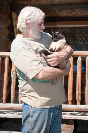 Ken Fulford and his cat with an attitude, Tai Chi, manage to co-exist as roommates in Fulford's Mt. Hull log cabin. Brent Baker / staff photo