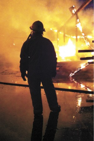 An Oroville firefighter is silhouetted by the flames at the fire Thursday, Nov. 2. Debra Donahue/submitted photo.