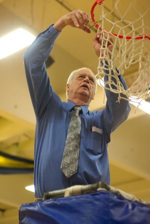 Oroville girls basketball coach Mike Bourn cuts down the net after the Hornets wrapped up the Central Washington  2B League North Division title with a 44-34 victory over Lake Roosevelt on Tuesday, Feb. 11.