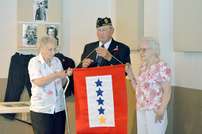 R.L. "Louie" Wilson, Commander of Hodges Post #84 of the American Legion in Oroville, presents  a Five Star Banner  to Delores Thornton Hogue of Oroville and  Margaret Thornton Malm of Wenatchee.