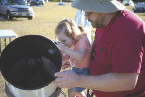 Zach Drew gives daughter Lily a chance to peer through his telescope at the Table Mountain Star Party last week, hosted at Eden Valley Guest Ranch. 