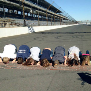 The FFA group kisses the bricks at the Indianapolis Speedway.