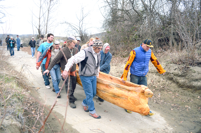 Friends join Churchill Clark in carrying his latest carve, a dugout canoe called Crazy Mary, for a first launch at Chief Tonasket Park Sunday, March 22. Katie Teachout photos