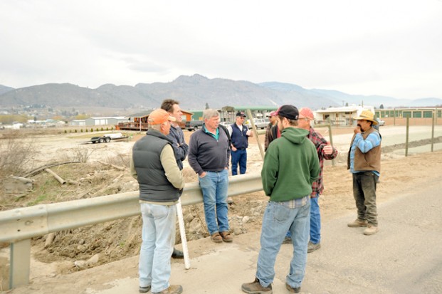 Jeff Bunnell, Chris Fisher and Rod Noel speak with area property owners abut the reoccurrence of  Tonasket Creek overflowing its banks and causing property damage. Fisher, a fish biologist with the Colville Tribal Fish and Wildlife Agency, said he  wouldn't be opposed to work being done to deepen and widen the creek bed. Gary DeVon/staff photo