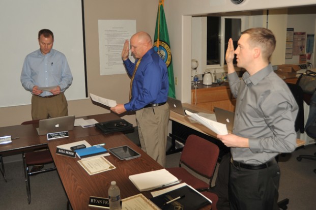 New Oroville School Directors Kolo Moser  (center) and Ryan Frazier are sworn onto  the school board by Superintendent Steve Quick at the last meeting of the board for 2016.