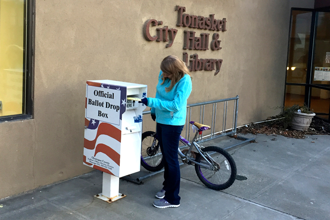 Gary DeVon/staff photo A Tonasket area voter drops her ballot off at one  of three ballot boxes in the county. According to Tonasket Mayor Patrick Plumb and City Clerk Alice Attwood, the box outside City Hall has been well used, with  voters dropping off their  ballots as late as 7:59 p.m. on election night.