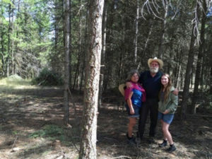 Submitted photo Tree, John, and Lydia Kiesecker standing by a completed thinning unit (left of photo) and a piece to be completed this fall (right of photo).