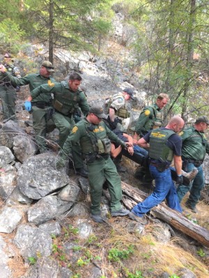 USBP photo Members of the U.S. Border Patrol, Curlew Station, help a person who had threatened suicide down a hill.