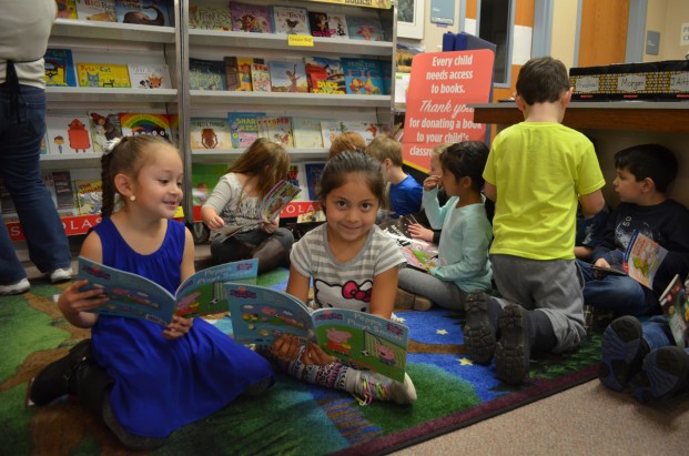 Katie Teachout/staff photo Students in Mrs. Weller's kindergarten class peruse books chosen at the book fair, including these girls who were thrilled when four of them got to choose the same book, "Peppa Plays Soccer."