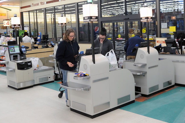 Gary DeVon.staff photo Customers use the new self-checkout stands at Akins Foods.