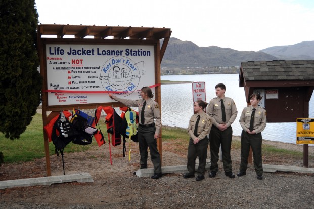 Gary DeVon/staff photo Oroville Border Patrol Explorers (L-R) Katelyn Whiteaker, Teresa Fast, Mark Fast and Melinda Clark at the dedication of the new life jacket donor station at Oroville. Patrol Explorer in Charge Whiteakier said that the post raised funds to build the two stations and Midway Building Supply donated much of the materials. 