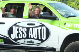 At the start of the rodeo, Grand Marshals Tim and Julie Alley catch a ride in the Jess Auto truck and greet the crowd.