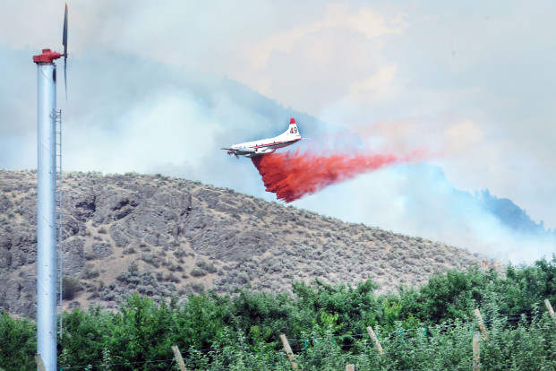 Gary DeVon/staff photo A tanker plane drops a load of retardant on the O'Neil Fire Wednesday afternoon. The fire had people lining up along O'Neil Road to watch planes and helicopters bomb the fire.