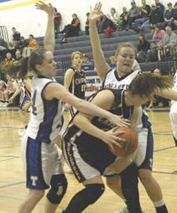 Photo by Terry MillsTigers Katy Keeton and April Webber make a tough defense against Omak.