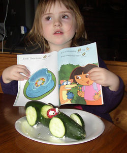 Submitted photo                Kaylee Clough posing with her new book and her completed cucumber car.