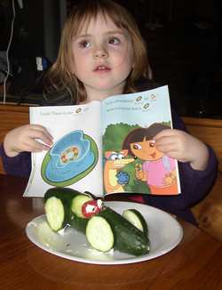 Submitted photo                Kaylee Clough posing with her new book and her completed cucumber car.