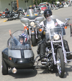 Photo by Gary DeVon    Jackson Gregg, gets a ride in a sidecar from Verna Madison, a member of the Columbia River Harley Owner's Group. The fourth-grader, who had an operation last year for a brain tumor, was helped by the group which ra