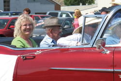 Photo by Amy VenezianoGrand Marshall Neil Robinson, outside, salutes the crowd from a vintage car.