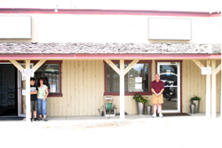 Photo by Gary DeVon Colleen Brown (left) stands next to the new temporary location of the Washington State Liquor Store. Next door is Steve Smith and his Grange Insurance Agency. Both businesses had to move after the buildi