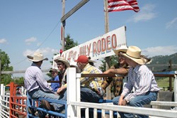 Photo by Gary DeVon&amp;nbsp;&amp;nbsp;&amp;nbsp; GOOD DAY TO BE A COWBOY - A little bull pen action was taking place above the chutes. The Chesaw Fourth of July Rodeo has attracted cowboys (and cowgirls) over several gener