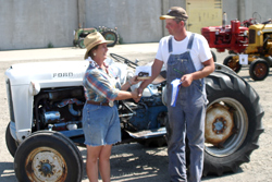 Photo by Gary DeVon    Ellen Newton awards Mike Mulholland his first place championship ribbon for winning the Slow Tractor Race driving his 1962 Ford.