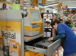 Amber McKinnon at Al’s IGA in Tonasket working at the Kodak kiosk during her shift. Al Seccomb, owner of Al’s IGA, said he thinks people made Christmas more of a food holiday this year than a gift holiday.Photos by Emily Hanson