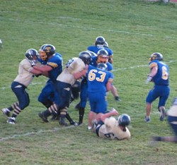 Junior running back Keegan McCormick (6) makes his way past Bow Valley defensive linemen as the Tigers block for him during Tonasket’s 48-34 victory over the Canadian team. Also shown is junior defensive lineman Stephen Hulse (63).Photo by Emily Hanson