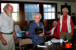 Richard Rise, President of OCHS, presents Claire Rise with the Pioneer of the Year award as Mary Louise Loe, president of the Molson Museum looks on.