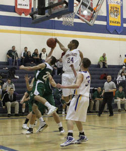 Tonasket senior Terrell Cross jumps up to stop Chelan freshman Michael Amsel, Jr. (20) from scoring during Tonasket’s home loss to Chelan on Tuesday, Dec. 15. Also shown is junior Corbin Moser (32). Photo by Terry Mills