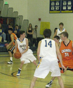 Tonasket junior Corbin Moser looks for an open teammate to pass the ball to during the Tigers’ home loss to Cashmere on Saturday, Jan. 9. Also shown is senior Blake Long (14) and junior Zach Neal. Photo by Emily Hanson