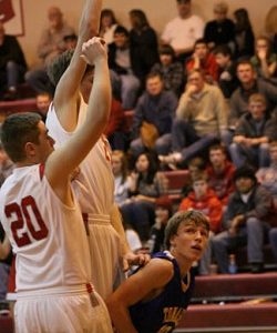 Tonasket sophomore John Stedtfeld crouches down to make a jump shot despite two tall Cascade defenders preparing to block the shot during Tonasket’s loss to Cascade on Saturday, Jan. 16. Photo by Ian Dunn