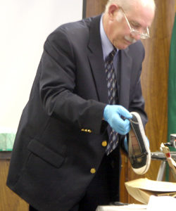 Detective Mike Murray holds up Michelle Kitterman's left shoe, which was found near her body, for the jury to see as evidence toward the end of testimony Monday, April 19. Murray also showed the shirt, jacket, jeans and bra Kitterman was wearing the night